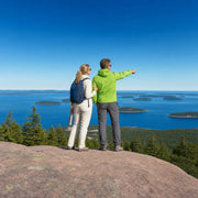 Couple on a granite summit overlooking spruce islands and the Atlantic, Acadia National Park Tour experience gift
