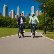 Couple cycling a car-free park loop with towers beyond the trees, New York City Adventure experience gift