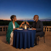 Couple raising wine glasses across a candlelit terrace table at dusk, Anniversary Experiences experience gift