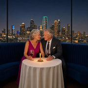 Couple holding hands at a candlelit window table, Anniversary in Dallas Experience Collection experience gift