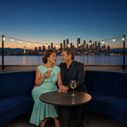 Couple sharing a quiet toast at a rooftop lounge above Puget Sound, Anniversary in Seattle experience gift