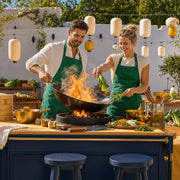 Couple cooking with a flaming wok in a sunlit market courtyard, Asian Cooking Experience Collection experience gift