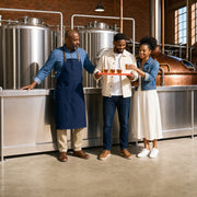 Guide walking a couple through a flight of amber tasters in a brewhouse, Beer & Brewery Tours experience gift
