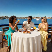 Three friends toasting mimosas over pastries on a cruise deck, Brunch Cruise experience gift