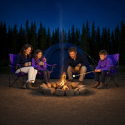 Family toasting marshmallows around a stone fire ring at dusk, Camping Adventure experience gift