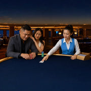 Dealer sliding a card across navy felt as a couple leans in, Casino & Gaming experience gift