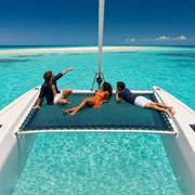 Three friends on a catamaran bow trampoline heading for a sandbar, Catamaran Cruises experience gift