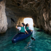 Tandem kayak gliding through a limestone sea cave toward daylight, Cave Kayak Tour experience gift