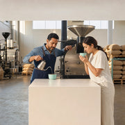 Roaster pouring water into a cupping bowl as a guest breathes in the aroma, Coffee & Tea experience gift