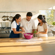 Instructor guiding a couple through mixing at a teaching kitchen island, Cooking Classes experience gift