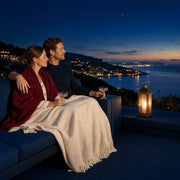 Couple under a throw with drinks on a resort terrace above a bay at dusk, Weekend Escape experience gift