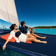 Couple reclining on a catamaran trampoline gliding a turquoise bay, Smooth Sailing experience gift