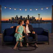 Couple with cocktails on a rooftop lounge sofa above the bay, Date Night in Seattle experience gift