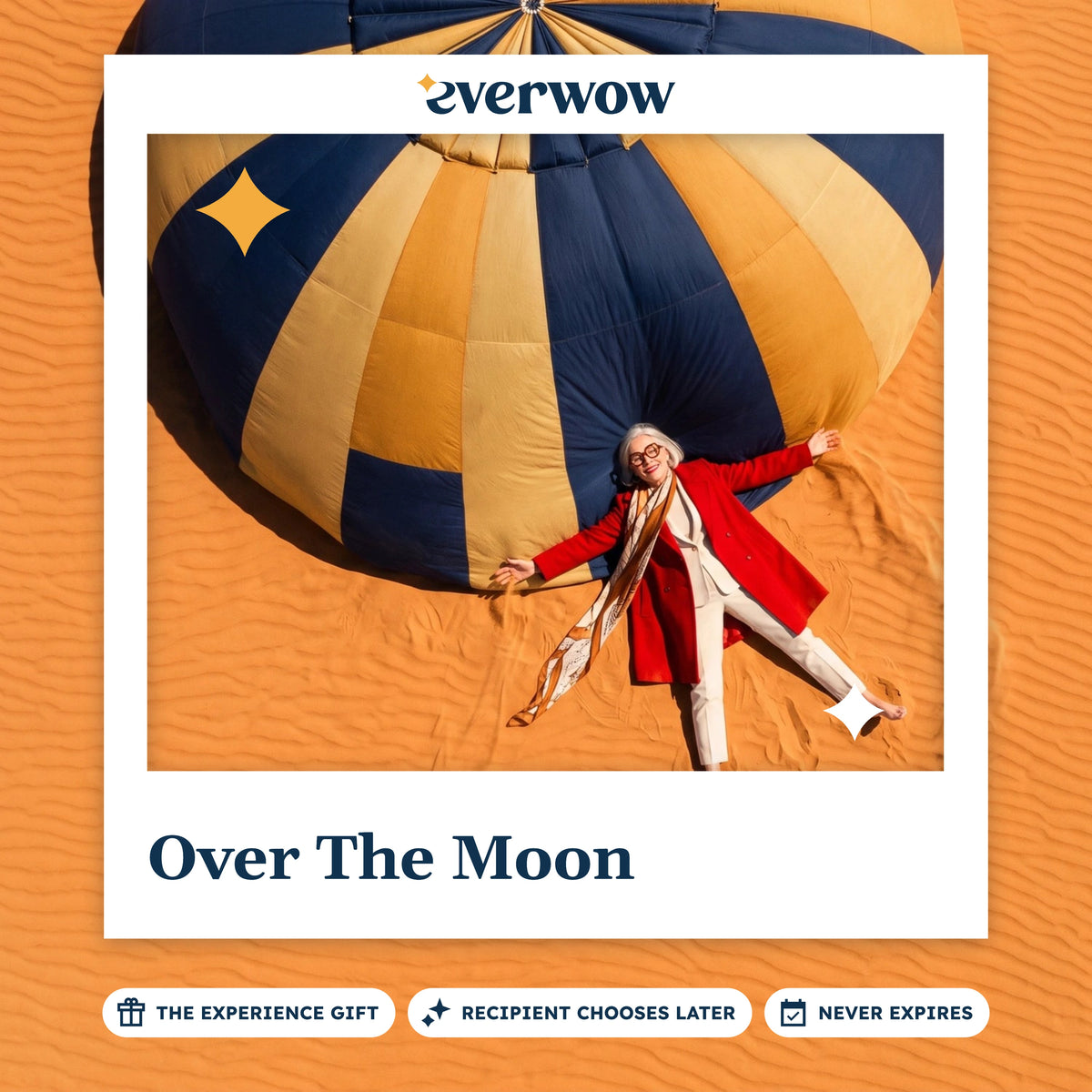Everwow Over The Moon experience gift card: woman lying on desert sand beside a hot air balloon