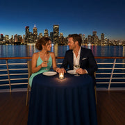 Couple lingering over wine on a dinner cruise as the city skyline glitters, Dinner Cruise experience gift