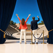 Couple cheering toward the stage of an open-air amphitheater, Showtime experience gift