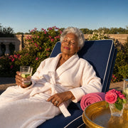 Grandmother relaxing on a garden lounger at evening, eyes closed, Grandma Glow experience gift