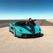 Student at the wheel of a sports car as an instructor points down the track, Ferrari Driving experience gift