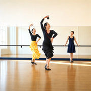Flamenco instructor and student practicing a turn in a sunlit studio, Flamenco Class experience gift