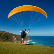 Paraglider pilot launching off a coastal bluff above a turquoise sea, Sky High experience gift