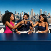Three friends toasting coupes at a rooftop bar over the skyline, Night Out experience gift
