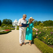 Couple strolling a botanical garden path with a map and blooms, Garden & Botanical Tours experience gift