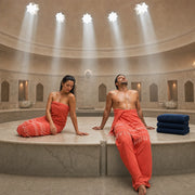 Woman pouring water from a copper bowl in a steamy domed hammam, Hammam & Turkish Bath experience gift
