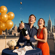 Couple popping champagne on a rooftop, cork frozen mid-flight, Milestone Reached experience gift