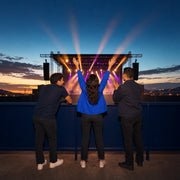 Three friends cheer at the front rail as stage lights sweep, Live Music & Concert experience gift
