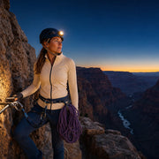 Climber standing on a via ferrata ledge at dusk with a headlamp, Iconic Adrenaline Luxe experience gift