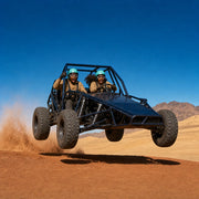 Dune buggy catching air off a sand crest with two helmeted riders, Off-Road Buggy Adventure experience gift