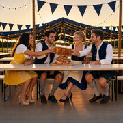 Four friends clinking steins at a festival tent table, Oktoberfest experience gift