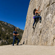 Climber reaching for a hold as her belayer holds the rope, Outdoor Rock Climbing experience gift