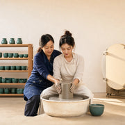 Instructor guiding a student's hands at the pottery wheel, Pottery & Ceramics Classes experience gift