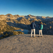 Couple pausing above an alpine lake on a high mountain range, Iconic Adventure experience gift