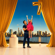 Parent lifting a child reaching up toward a giant number balloon over the city, Iconic Make a Wish experience gift