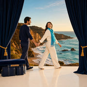 Couple walking hand in hand toward an evening coastline, bags packed, Iconic Bucketlist experience gift