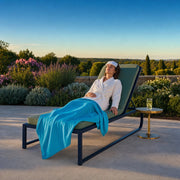 Woman resting on a lounger with a cool cloth on a garden spa terrace, Iconic Spa Bliss experience gift