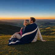Couple wrapped in one blanket watching a hilltop sunset, Romantic Experience Collection gift