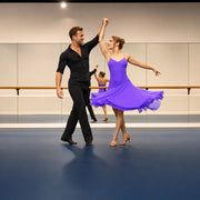 Student spinning under her instructor's raised hand in a studio, Salsa Dance Class experience gift