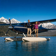 Pilot guiding a passenger onto a seaplane pontoon at a remote alpine lake, Bush Plane & Seaplane Tour experience gift