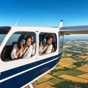 Couple in headsets watching patchwork farmland from a small aircraft, Scenic Flights experience gift