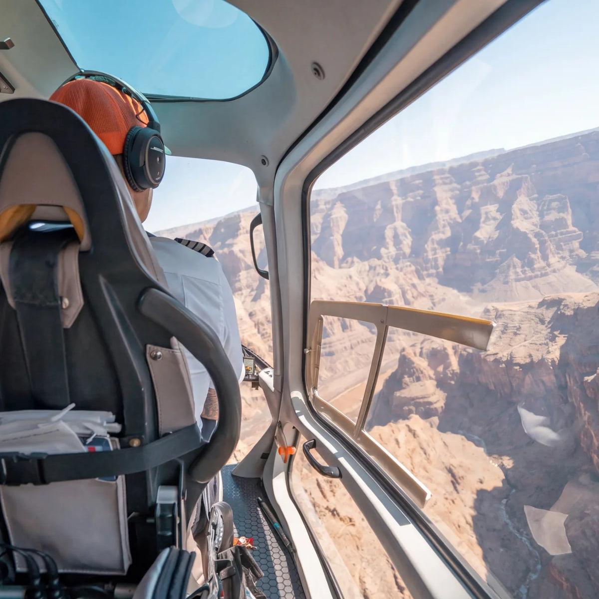 View from a helicopter cabin across layered canyon walls on a scenic flight