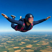 Skydiver in freefall with arms spread over patchwork farmland, Sky's the Limit experience gift