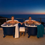Couple soaking in twin clawfoot tubs by candlelight on a sea-view terrace, Couples Haven experience gift