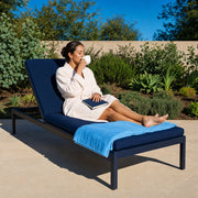 Woman sipping herbal tea on a lounger in a sunlit garden, Self Care experience gift
