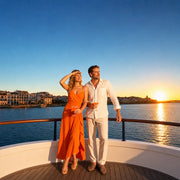 Couple with cocktails at the bow rail as the sun sets over the harbor, Sunset Cruise with Drinks experience gift