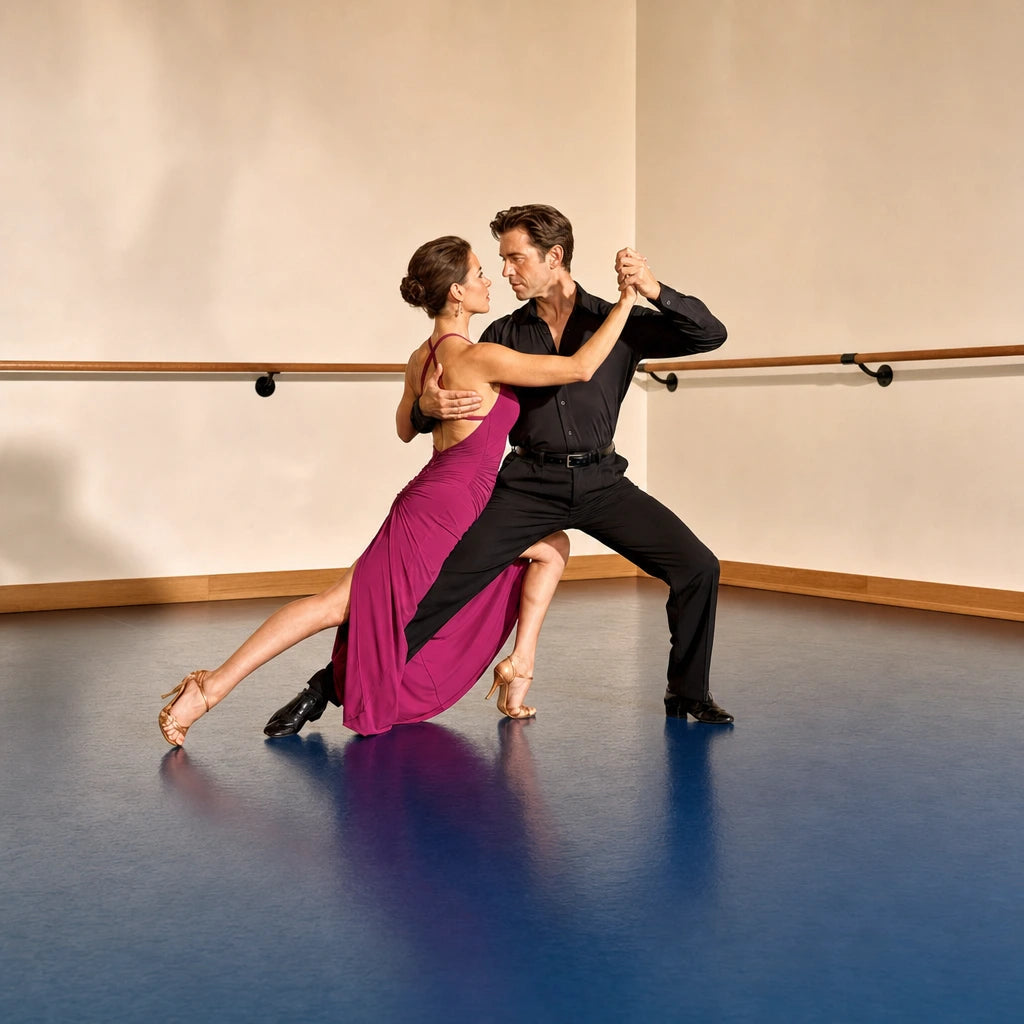 Couple in a long tango step on a studio floor, hands clasped high, Tango Dance Class experience gift