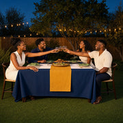 Four friends raising a toast over shared dishes at a backyard table, Friendsgiving experience gift