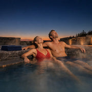 Couple relaxing in a steaming mineral pool at dusk, Thermal & Hot Springs experience gift